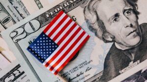 From above of small American flag placed on stack of 20 dollar bills as national currency for business financial operations